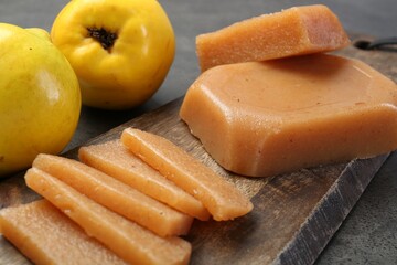 Tasty sweet quince paste and fresh fruits on grey table, closeup