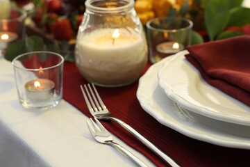 Stylish table setting with burning candles, closeup. Romantic dinner