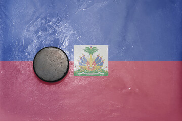 old hockey puck is on the ice with national flag of haiti . - obrazy, fototapety, plakaty