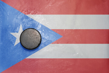 old hockey puck is on the ice with national flag of puerto rico .