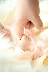 parent holding baby hand