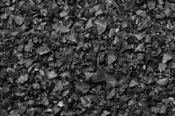 Black salt flakes close up full frame as background  