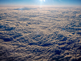 Sunrise clouds carpet view from airplane window while flying