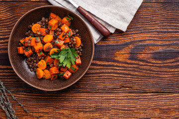 Comfort food with roasted sweet potatoes, lentils and herbs, delicious lunch or dinner, high angle view - Powered by Adobe