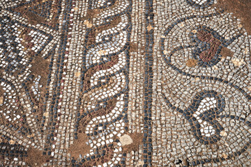 fragment of a stone floor with an ancient mosaic with geometric patterns on the island of Crete