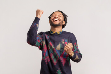 Portrait of extremely happy joyful african-american man with dreadlocks and beard standing with...