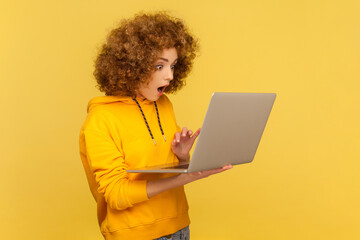 Side view portrait of astonished shocked woman with Afro hairstyle working online on laptop, find...