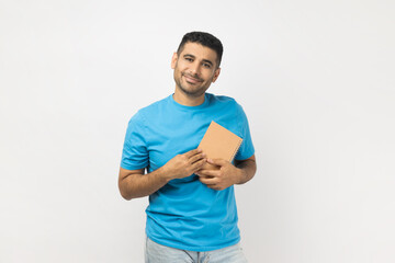 Portrait of joyful cheerful positive smiling unshaven man wearing blue T- shirt standing holding...