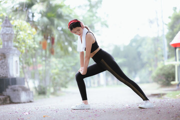 Beautiful Asian female runner doing morning exercise outdoors in city park. smile happily Exercise...