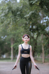 Beautiful Asian female runner doing morning exercise outdoors in city park. smile happily Exercise for good health