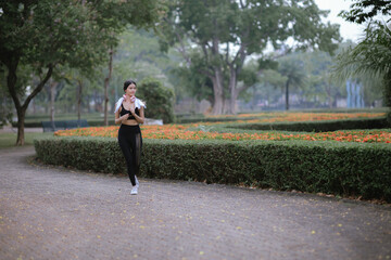 Fototapeta premium Asian woman exercising in the park Her gaze was determined to lose weight. The concept of healthy lifestyle activities