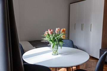 Wazon z tulipanami na stole w pokoju