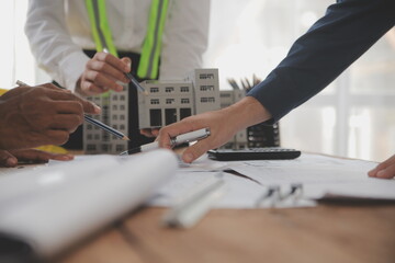 Construction and structure concept of Engineer or architect meeting for project working with partner and engineering tools on model building and blueprint in working site, contract for both companies.