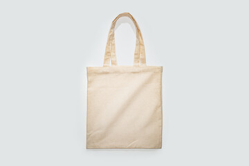A simple beige canvas tote bag displayed against a white backdrop.