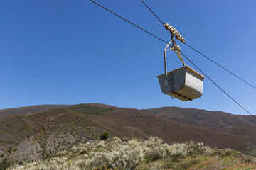 Coal mining cart on rope way cable way abandoned industrial equipment in the mountains on a clear...