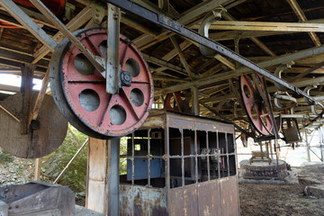 Steel metal wheel in industrial coal mining factory building with beams in Tormaleo Asturias.