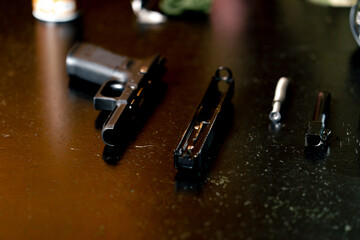 in a professional shooting range on a black table lies disassembled pistol device details
