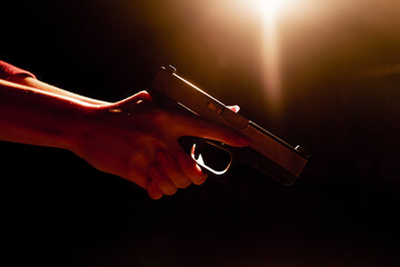 close-up of female hands holding pistol contrast light readiness to shoot correct position of hands