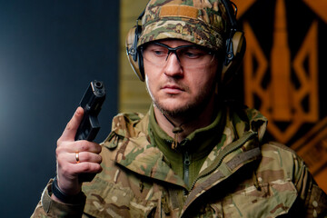 close-up at a professional shooting range military man stands in ammunition and holds a pistol