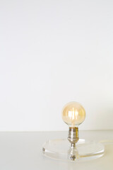 Post-modern light with a clear base and a bare Edison bulb.