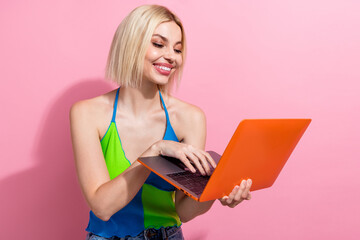 Portrait of clever focused girlish woman with bob hairstyle wear colorful top look at laptop...