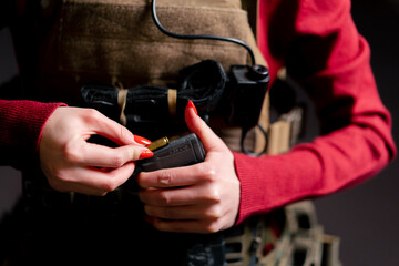 close up At a professional shooting range a guy in tactical ammunition loads a magazine with...