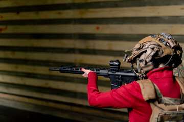 In a professional shooting range young girl in tactical ammunition is preparing to shoot