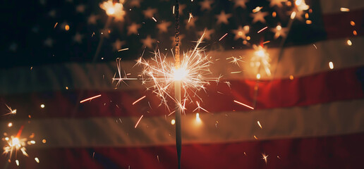 Sparklers illuminate an American flag, creating a festive 4th of July atmosphere, shallow field of view.