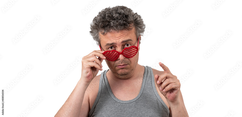 Wall mural Gray-haired, shaggy, unshaven middle-aged man in a sleeveless T-shirt wearing sunglasses in the shape of a human heart symbol - Wall murals