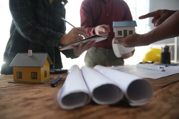 Engineers are consulting the team to design an architectural structure for clients with blueprints...