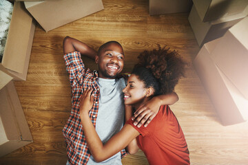 Relax, embrace and happy couple on floor in new home with boxes, laugh and mortgage with high...