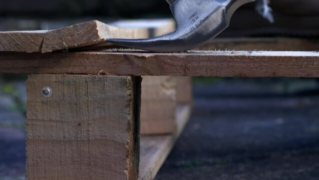 Work boots with recycling wooden industrial pallet with a hammer background