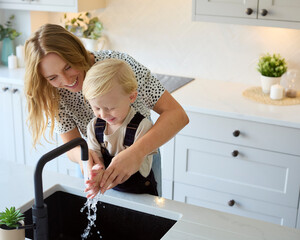 Overhead Shot Of Mother With Son At Home In Kitchen Washing Hands In Sink Or Basin Together