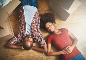 Sleep, fatigue and black couple on floor in new home with cardboard boxes, tired and mortgage with...