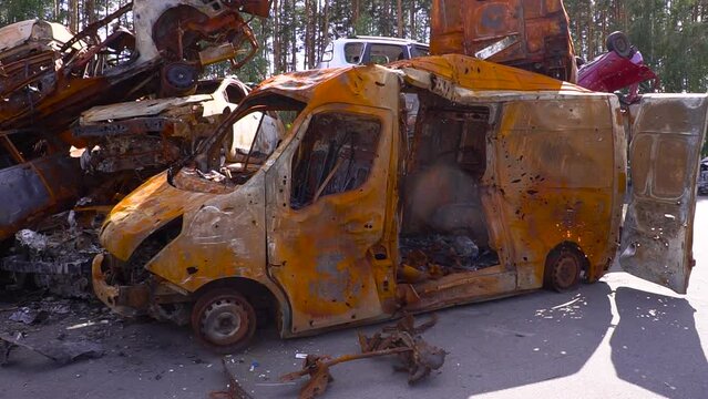 A yellow van is parked next to a pile of scrap metal on the side of the road