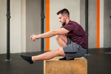 Strong man doing squats exercise on box