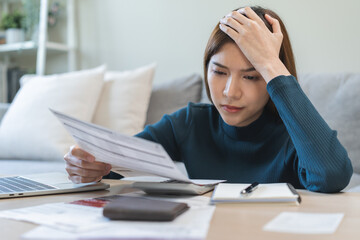 Stressed asian young employee, business woman calculate tax, income and expenses, hand looking...