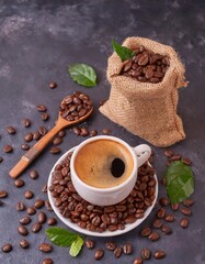  Top view of Cup of coffee and coffee beans in a sack on dark background
