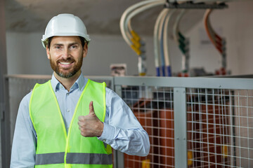 Happy technician contractor mechanic in hardhat helmet showing ok gesture recommend okay sign factory work