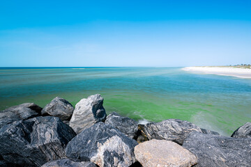 Mexico Beach, Florida USA rocky jettie emerald-blue waters white sandy beaches blue sky