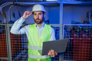 Professional Industry Engineer Worker Wearing Safety Uniform and Hard Hat Uses Laptop Computer.