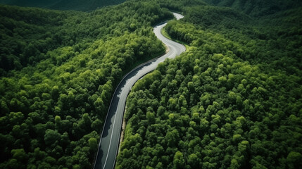 Aerial top view beautiful curve road on green forest, a winding road cutting through a dense, lush green forest