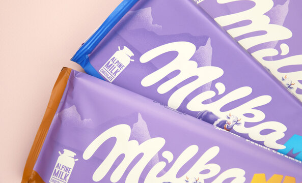 Chocolate brand Milka with Oreo flavor and caramel on a soft pink background.