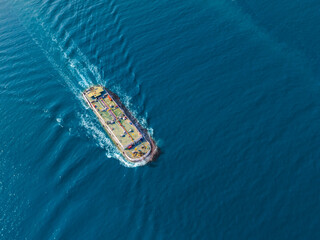 Aerial front side view of small mini oil tanker ship sailing on open sea