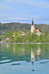 Obraz premium Assumption of Maria Church on Bled Island with Reflection Against Lake Bled in Slovenia