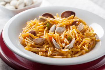 Noodles with tomato sauce and clams in fish broth