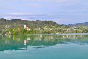 Obraz premium Assumption of Maria Church on Bled Island with Reflection Against Lake Bled in Slovenia