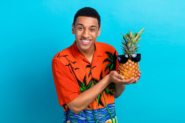 Photo of funky funny guy dressed print shirt holding pineapple wear dark glasses isolated blue...