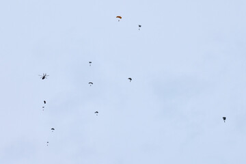Airborne forces paratroopers soaring holding Flag of Russia and flags of military units, military exercise for celebration of Airborne Forces Day with formation landing, army airborne division descend