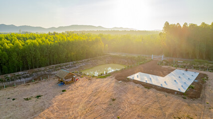 Obraz premium A view of a farmyard in the countryside and the sun coming up in the morning.